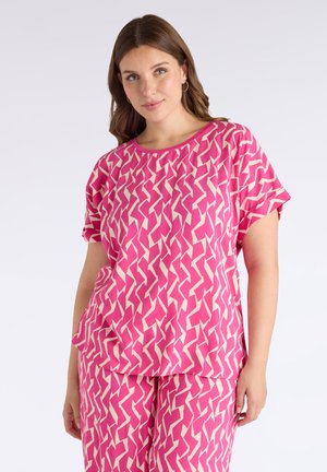 Top rosa a maniche corte con un motivo a zigzag crema, dotato di scollo rotondo e vestibilità ampia, realizzato in un tessuto leggero.