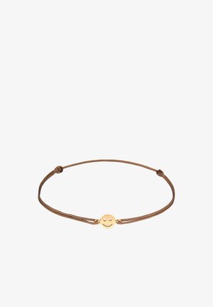 Rudas virvės apyrankė su centriniu aukso spalvos šypsenėlės pakabuku, turinčiu dvi apvalias akis ir lenktą šypseną.