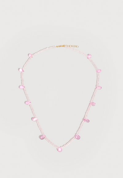 Collier délicat avec de petites perles roses translucides et de plus grosses perles roses en forme de goutte, fixé avec un fermoir chaîne en or.