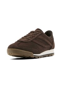 Brown suede athletic shoe with textured surface, rubber outsole, and contrasting white midsole. Features classic lace-up design and stitched details.