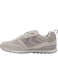 Baskets beige clair avec panneaux en daim et mesh, fermeture à lacets, deux bandes en chevron sur le côté, et une semelle en caoutchouc avec motif.