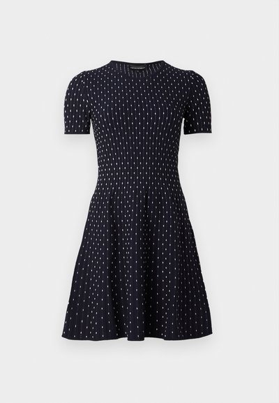 Short-sleeve navy dress with a fitted bodice, flared skirt, ribbed texture, and white dot patterns throughout.