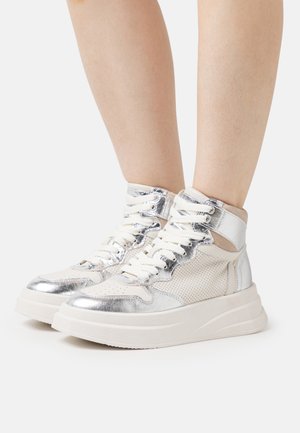 Hochschnitt-Sneaker aus silberner Metallic-Oberfläche und beigem Mesh, mit einer dicken weißen Sohle und beigen Akzenten, perforierten Details und weißen Schnürsenkeln.