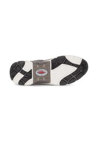 Zwarte rubberen zool met witte tussenzool, voorzien van een gestructureerd grippatroon en een zichtbaar logo. Rondvormig en flexibel ontwerp voor comfort.