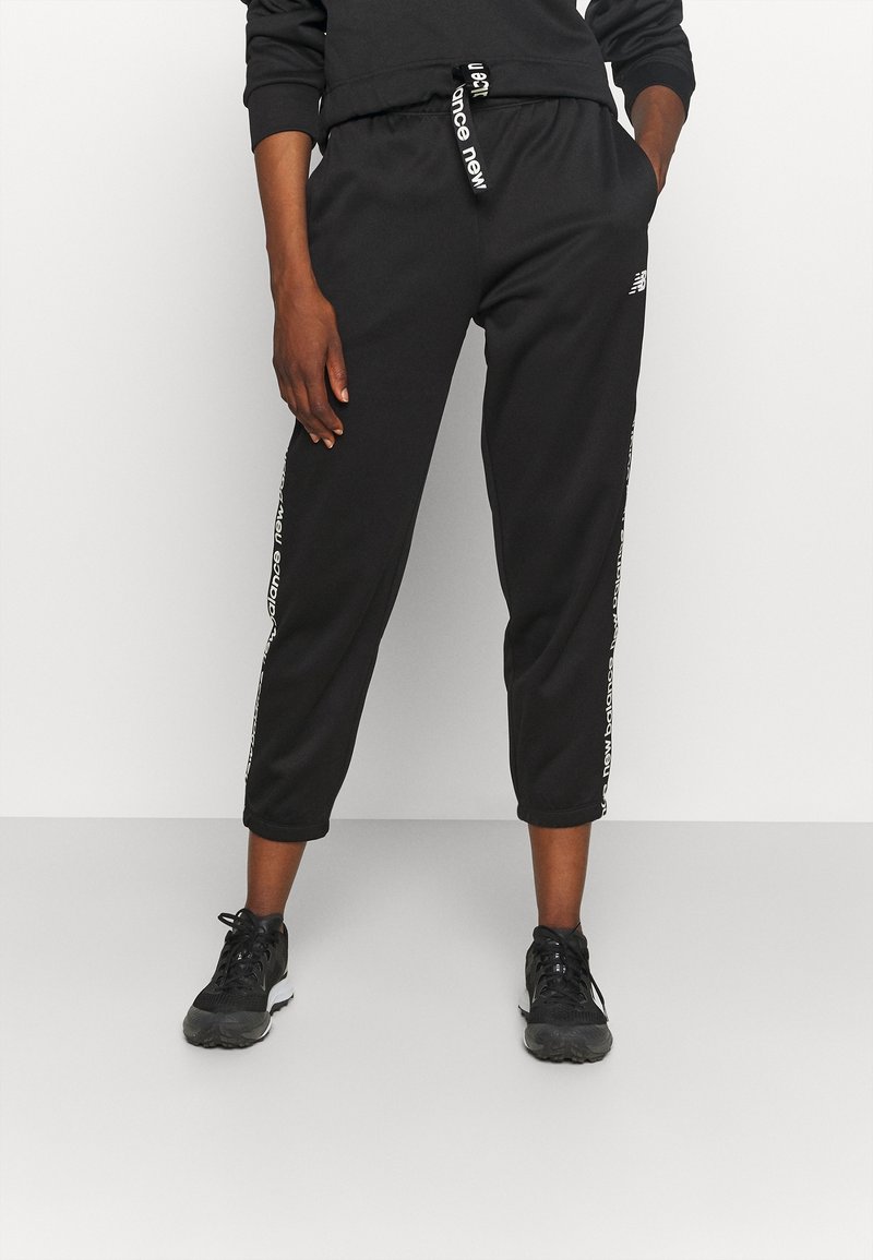 Zwarte joggerbroeken van zacht materiaal, met een elastische tailleband, zijlogo-accenten en een cropped lengte. Geschikt voor casual wear.