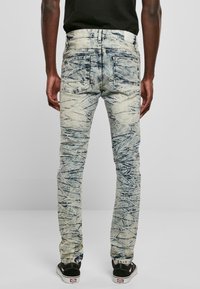 Vaaleansiniset farkut, joissa on teksturoitu, sahalaitamainen kuvio. Slim fit -malli, viisi taskua ja vahvistettu ommel saumoissa.