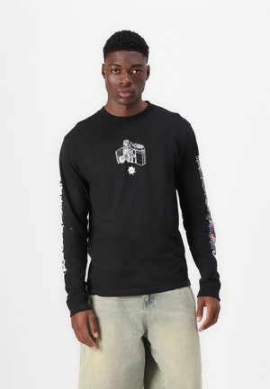 Schwarzes Langarm-T-Shirt mit einem Kameragraphik auf der Vorderseite und bunten Textdesigns an den Ärmeln. Aus glattem Stoff gefertigt.
