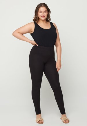 Débardeur noir associé à des leggings noirs. Le débardeur a une encolure ronde et les leggings présentent une taille sans couture et une coupe ajustée.