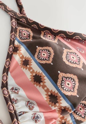 Brun mönstrad bikinitopp med korsade axelband, med geometriska mönster i rosa, vitt och blått. Mjuk textur med rynkad kant.