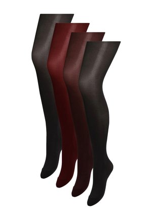 Frau modelliert transparente dunkelbraune Strumpfhosen auf Zehenspitzen vor einem einfarbigen hellen Hintergrund.