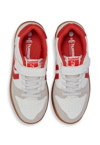 Weiße Sportschuhe mit roten Akzenten, ausgestattet mit einem Klettverschluss, einem durchlüfteten Zehenbereich und einer strukturierten Gummilaufsohle.