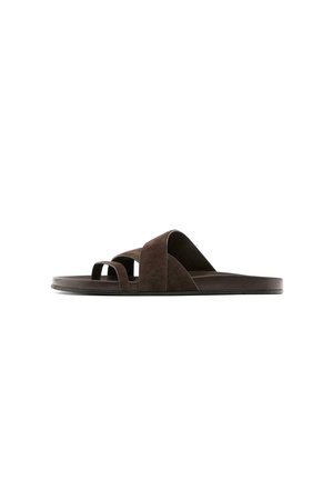 Sandale plate marron à enfiler avec des larges et fines lanières, bout ouvert et semelle basse, vue de côté sur fond blanc.