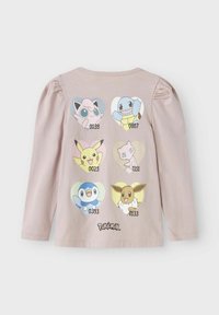 Camicia a maniche lunghe rosa chiaro con figure di Pokémon in forma di cuore sul retro, con numeri sotto ciascun personaggio e il testo "Pokémon".