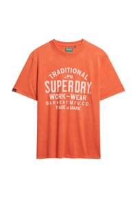 Orange bomulds T-shirt med rund hals, korte ærmer og hvidt trykt tekst, der siger "TRADITIONAL SUPERDRY WORK-WEAR."
