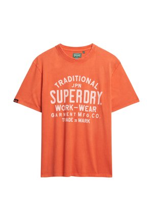 Oranje katoenen t-shirt met een ronde hals, korte mouwen en witte opdruk met de tekst "TRADITIONELE SUPERDRY WERKKLEDEN."