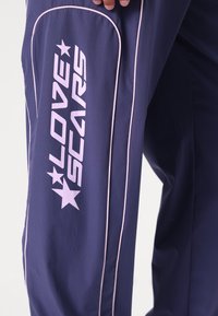 Love Scars COACH TRACKPANTS UNISEX - Παντελόνι - midnight purple