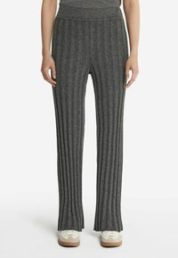 Grå ribbet strikkede bukser med en bredde design og blød tekstur, der har en bred talje, og er parret med lyse sneakers.