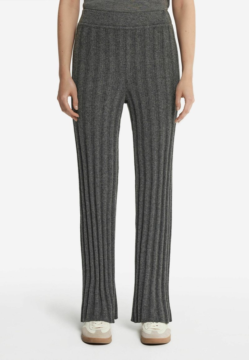 Grå ribbet strikkede bukser med en bredde design og blød tekstur, der har en bred talje, og er parret med lyse sneakers.