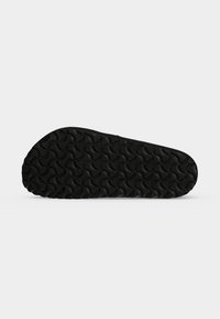 Μαύρη σόλα παπουτσιού με επαναλαμβανόμενο κυρτό κυματιστό μοτίβο πέλματος, απεικονισμένη επίπεδη σε λευκό φόντο.