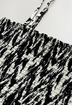 Czarnobiały top bez rękawów z teksturowanym, marszczonym wzorem oraz cienkimi ramiączkami umożliwiającymi regulację dopasowania. Wykonany z lekkiej tkaniny.