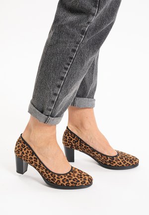 Brune leopardprint hæle med rund tå, sorte detaljer og en chunky hæl, parret med rullede grå denimbukser.