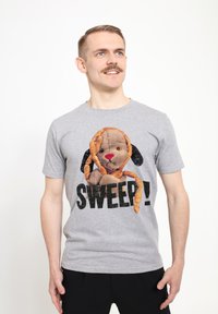 Šedé bavlněné tričko s potiskem karikatury psa s řetězem na sladkosti, odvážný černý text "SWEEP!" pod designem. Krátké rukávy, kulatý výstřih.