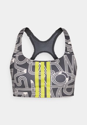 Brassière de sport noire avec motifs de lignes blanches abstraites. Présente trois bandes verticales jaunes. Conception dos nageur, texture lisse.