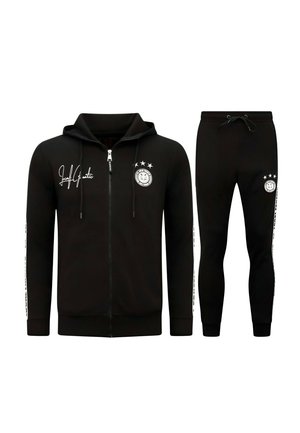 Zwarte zip-up hoodie en bijpassende joggerbroek met witte logo's en tekst op de borst, dij en mouwen, weergegeven op een witte achtergrond.