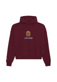 Bordowy hoodie z przednią kieszenią, z złotym emblematem i niebieskim tekstem "Social Club" umieszczonym na środku klatki piersiowej. Miękka, teksturowana tkanina.