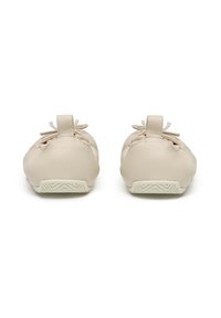 Scarpe in pelle beige chiaro dalla forma arrotondata, con un piccolo dettaglio a fiocco e una suola in gomma testurizzata con un motivo geometrico.