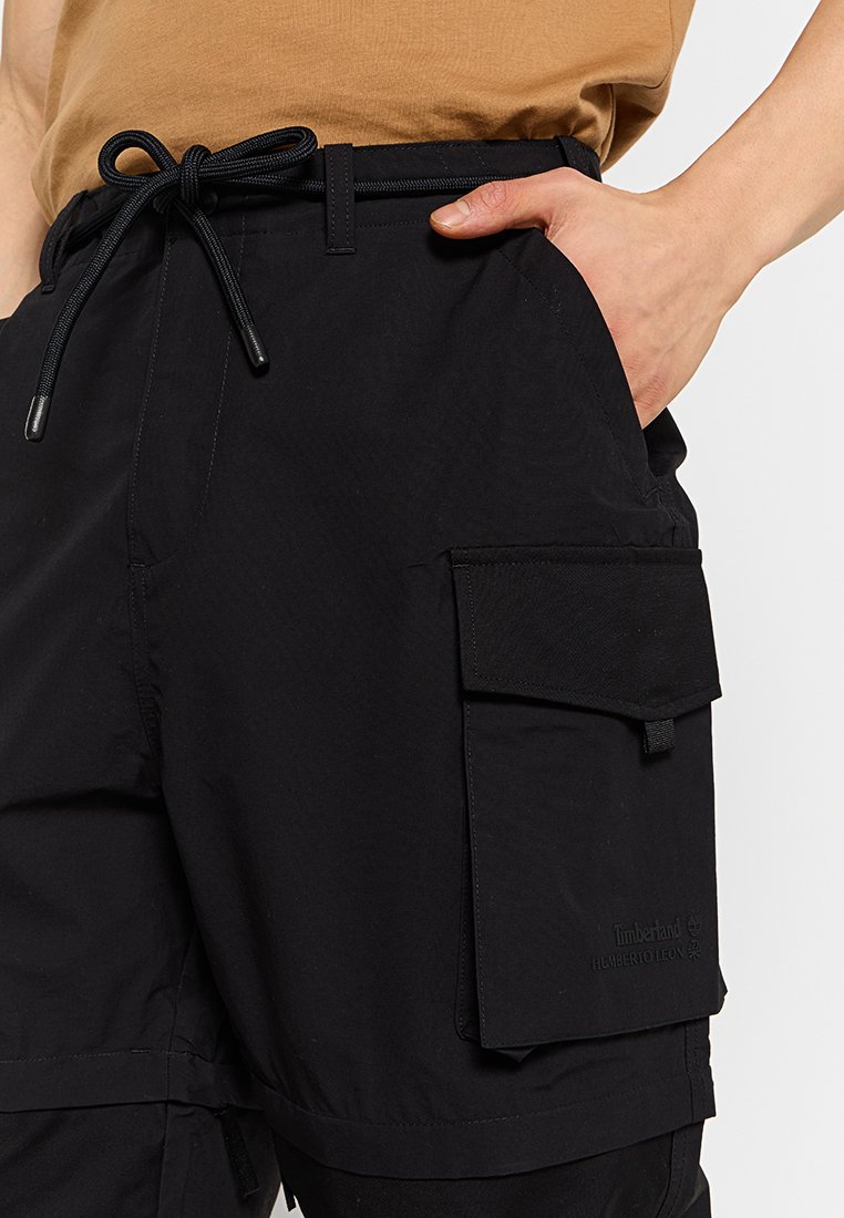 Shorts cargo noirs en tissu léger, dotés d'une taille à cordon de serrage, de poches latérales et d'une poche à rabat sur la jambe droite.