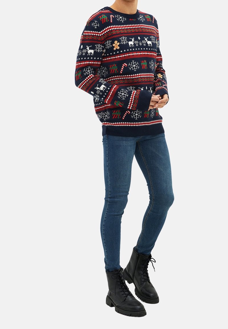 Knit sweater with a navy background, featuring red and green festive patterns, including reindeer, snowflakes, and gingerbread men.