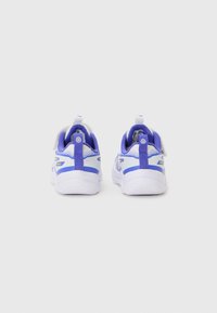 Chaussures de sport avec un dessus en maille blanche, des accents violets et un col rembourré. Présente une tirette à l'arrière et une semelle en caoutchouc texturée.