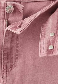 Chaqueta de mezclilla rosa con cierre frontal, botones de hardware plateado y un acabado texturizado; incluye un bolsillo en el pecho con solapa.
