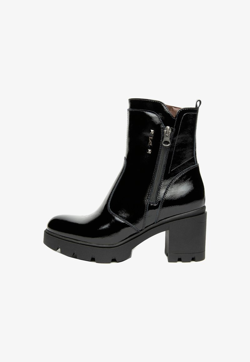 Botte de cheville en cuir verni noir avec un talon épais, fermeture à glissière sur le côté et accent clouté à l'avant. Semelle robuste avec des rainures pour l'adhérence.