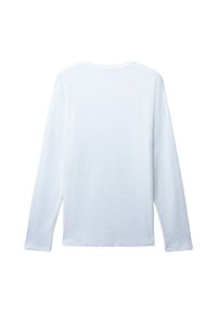 Camicia bianca a maniche lunghe con un sottile motivo a diamante, mostrata da dietro su uno sfondo bianco neutro.