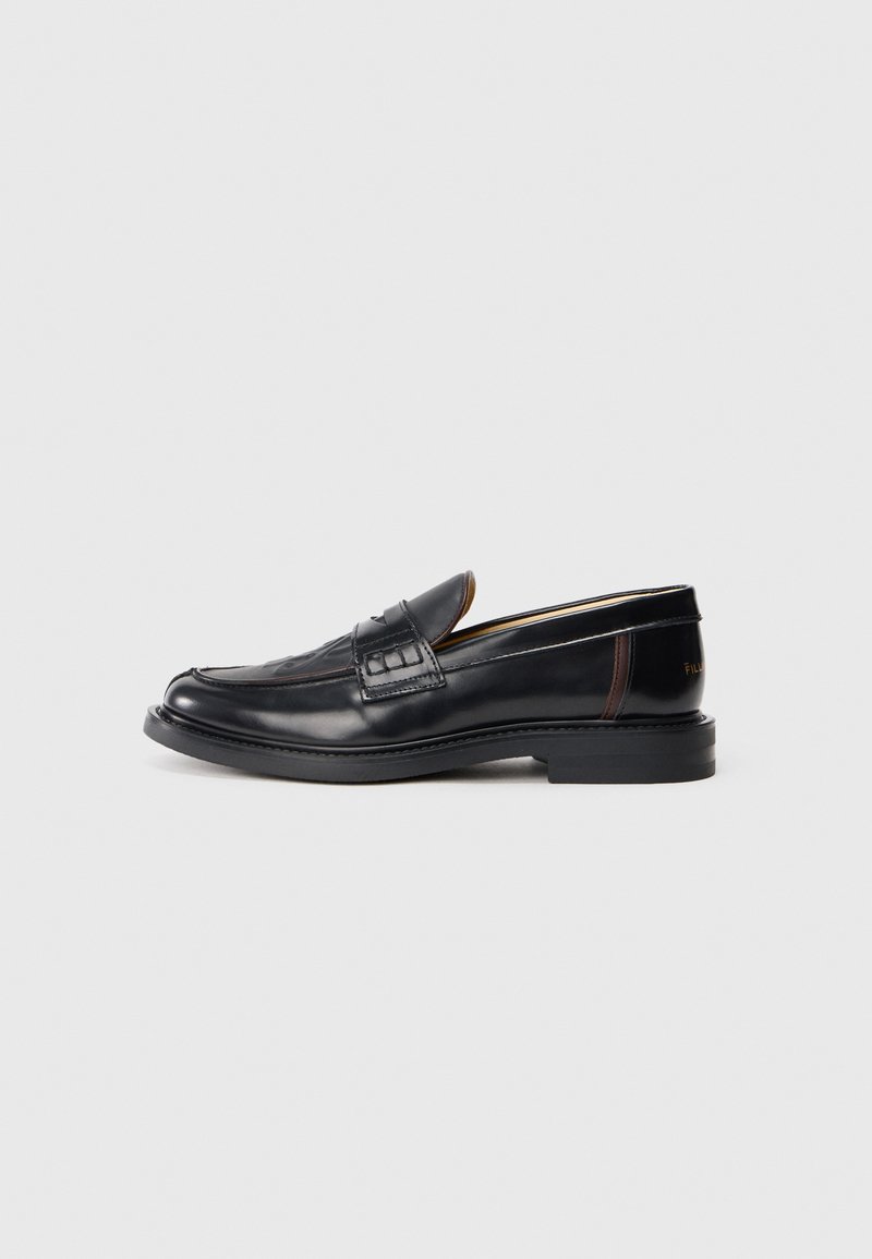 Mocassins en cuir noir avec une finition lisse, des coutures décoratives et un léger talon. Présente un petit panneau d'accent en marron.