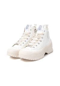 Zapatillas altas blancas de lona con suela texturizada, que cuentan con cierre de cremallera, diseño con cordones y detalle de logo en relieve.