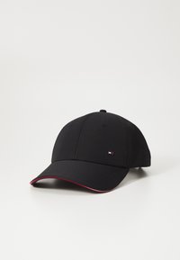 Cappellino da baseball nero realizzato in tessuto con una superficie liscia. Presenta un accento rosso sulla visiera e una piccola toppa con il logo sul fronte.