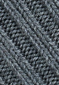 Tessuto a maglia grigia con un motivo a cable diagonale testurizzato che mostra fibre di filato intrecciate.