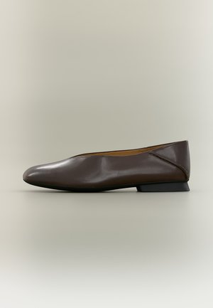 Chaussure plate en cuir marron foncé avec un bout légèrement pointu et un petit talon noir sur un fond neutre.