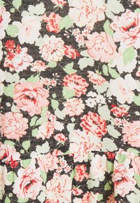 Tissu floral avec de grandes roses roses et blanches entourées de feuilles vertes sur un fond sombre, présentant un motif texturé.