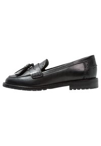 Zwarte leren loafers met een ronde neus, decoratieve franjes en brogue-accenten. Platte rubberen zool voor duurzaamheid. Gladde textuur.