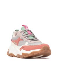 El calzado presenta una mezcla de materiales en rosa, gris y verde con una suela gruesa, acentos texturizados y un collar acolchado. Etiqueta de la marca visible.
