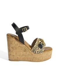 Sandale à plateforme en cuir noir avec une semelle en liège, empeigne tissée, accents en métal doré et bride de cheville réglable. Surface texturée et design à bout ouvert.