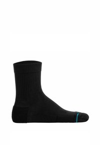 Calza nera con texture a coste, un tallone rinforzato e un accento blu vicino alla punta. Design di lunghezza media che offre una vestibilità aderente.