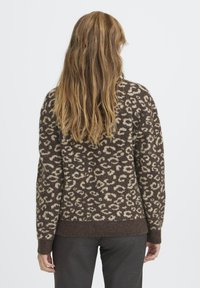 Pulover cu model leopard în nuanțe de maro și bej, cu mâneci lungi și tiv curbat, confecționat dintr-un material moale și texturat. Vedere din spate.