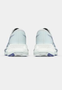 Chaussures de sport bleu clair avec tige en mesh, semelles blanches rembourrées et accents violets. Présentent un design texturé sur le talon et les côtés.