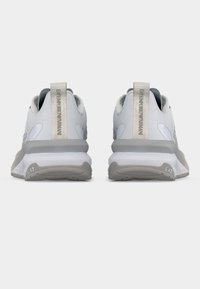 Ζευγάρι λευκών και γκρι αθλητικών παπουτσιών EA7 Emporio Armani, που φαίνονται από πίσω, δείχνοντας τις ετικέτες πτέρνας με το λογότυπο και τις γκρι σόλες.