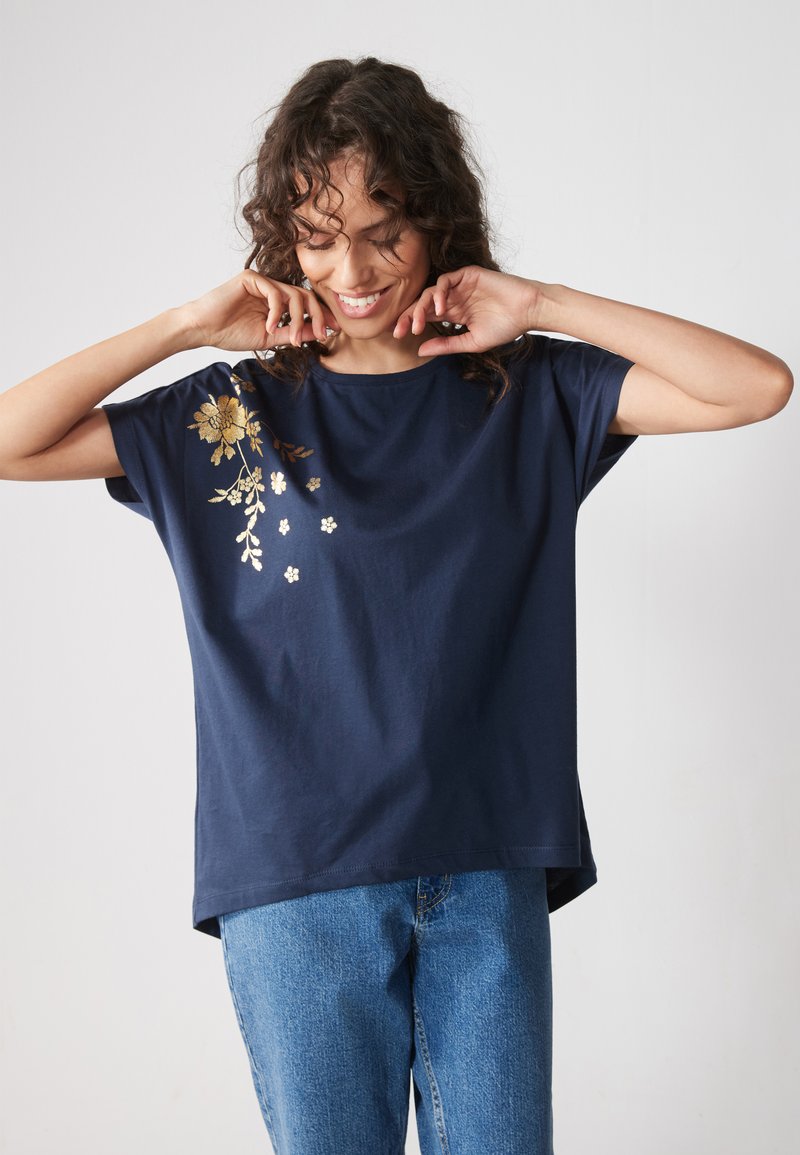 Navy blue cotton t-shirt with short sleeves, featuring gold floral embroidery and small white flowers on one side. Casual fit, soft texture.